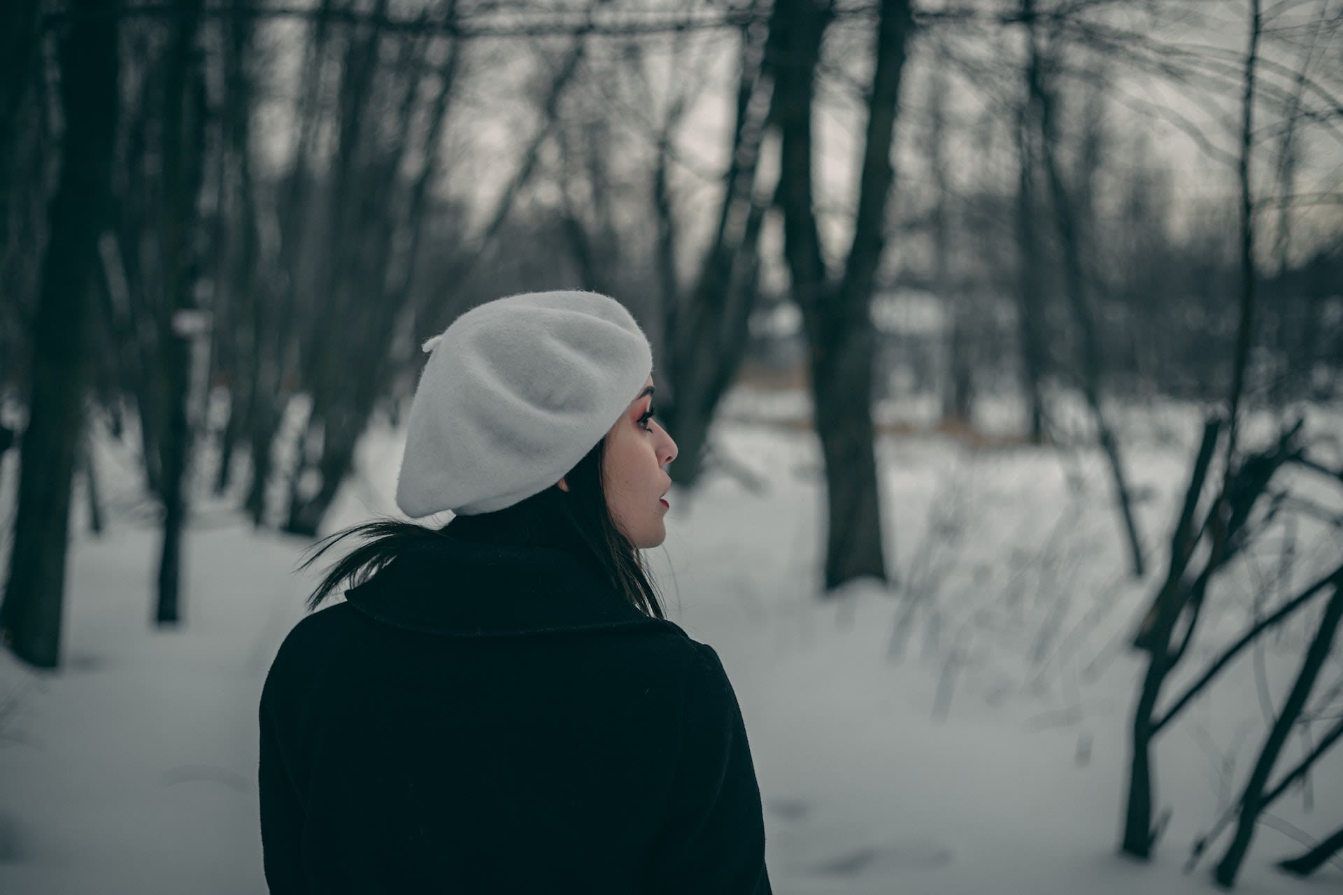 Woman wearing a white beret in the snow