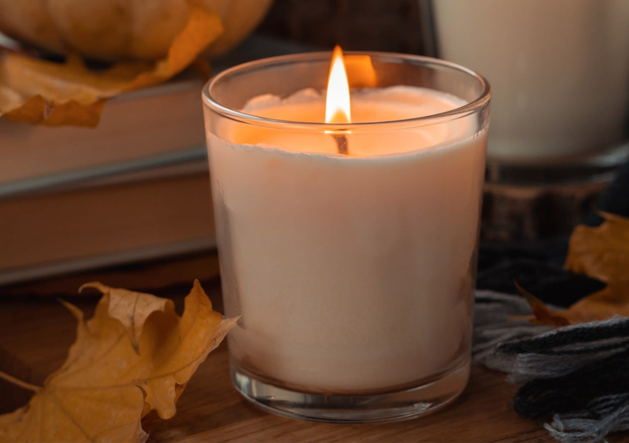 Second-hand lit scented candle on table