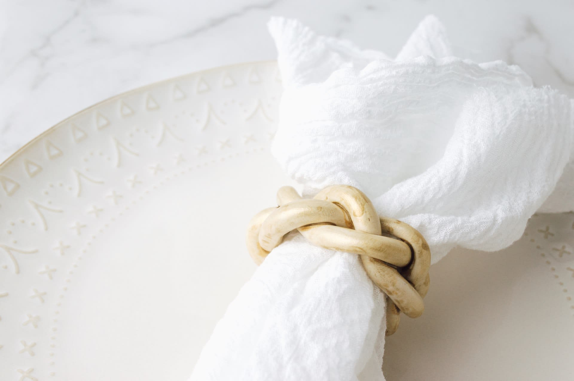 White napkin in a vintage bamboo ring on a dinner plate