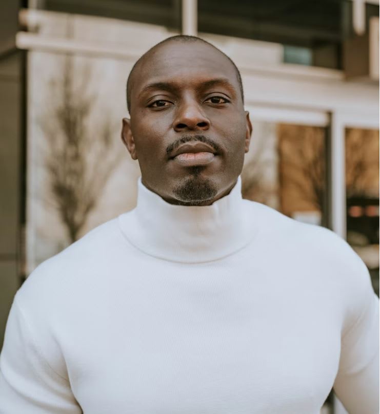 Man wearing white turtleneck looking straight at the camera