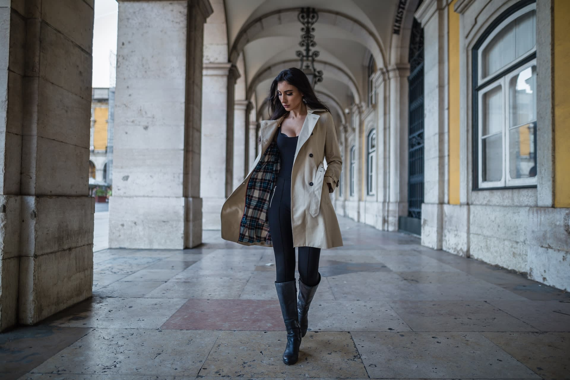 Woman wearing a beige trench coat with tartan lining