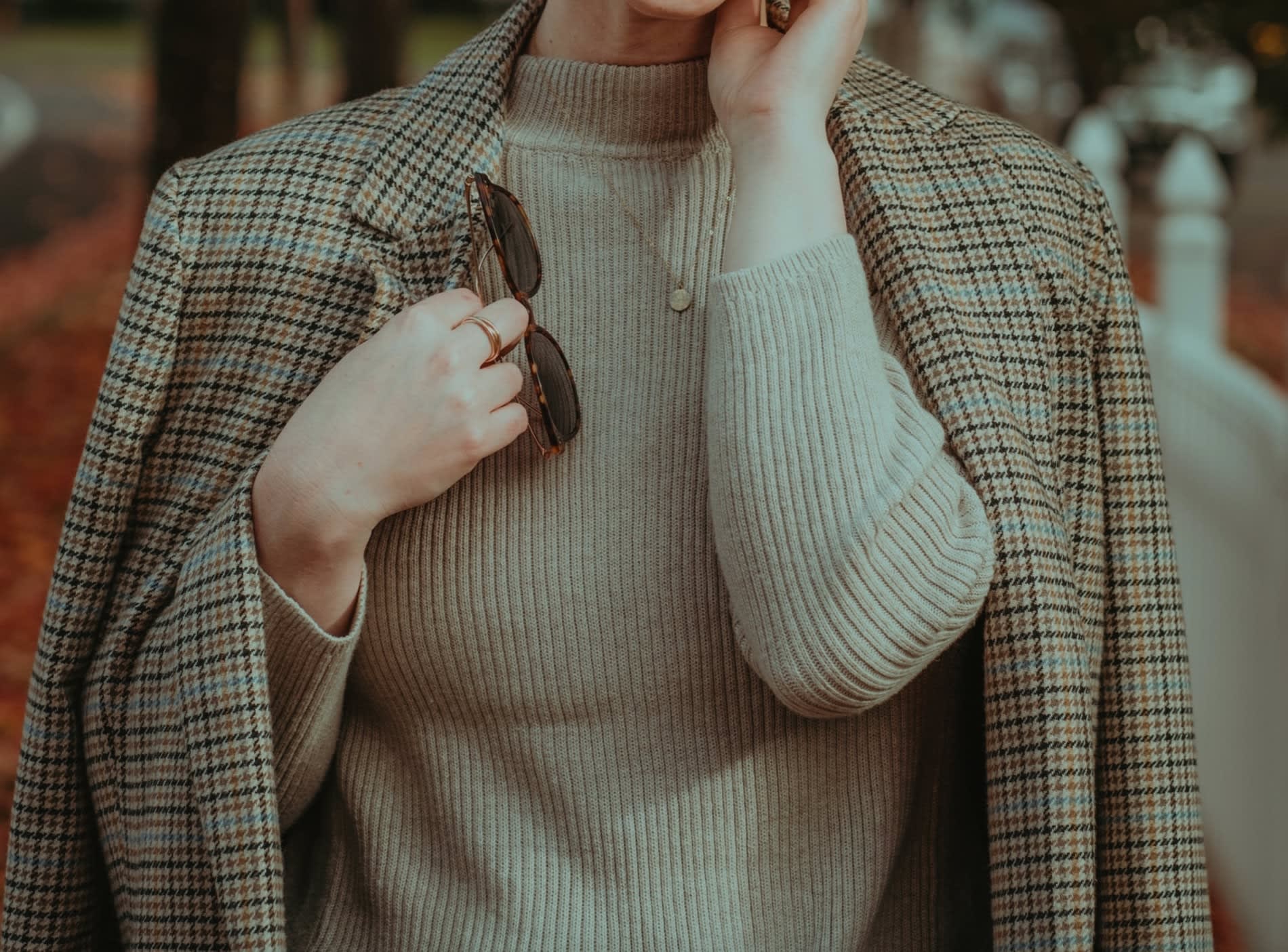 Woman wearing an oversized plaid blazer on her shoulders