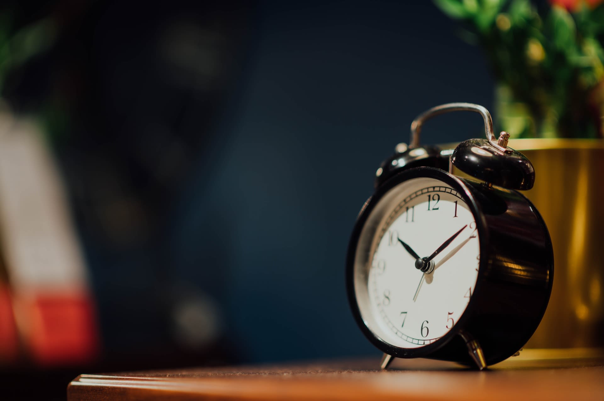 Black retro alarm clock on bedside table