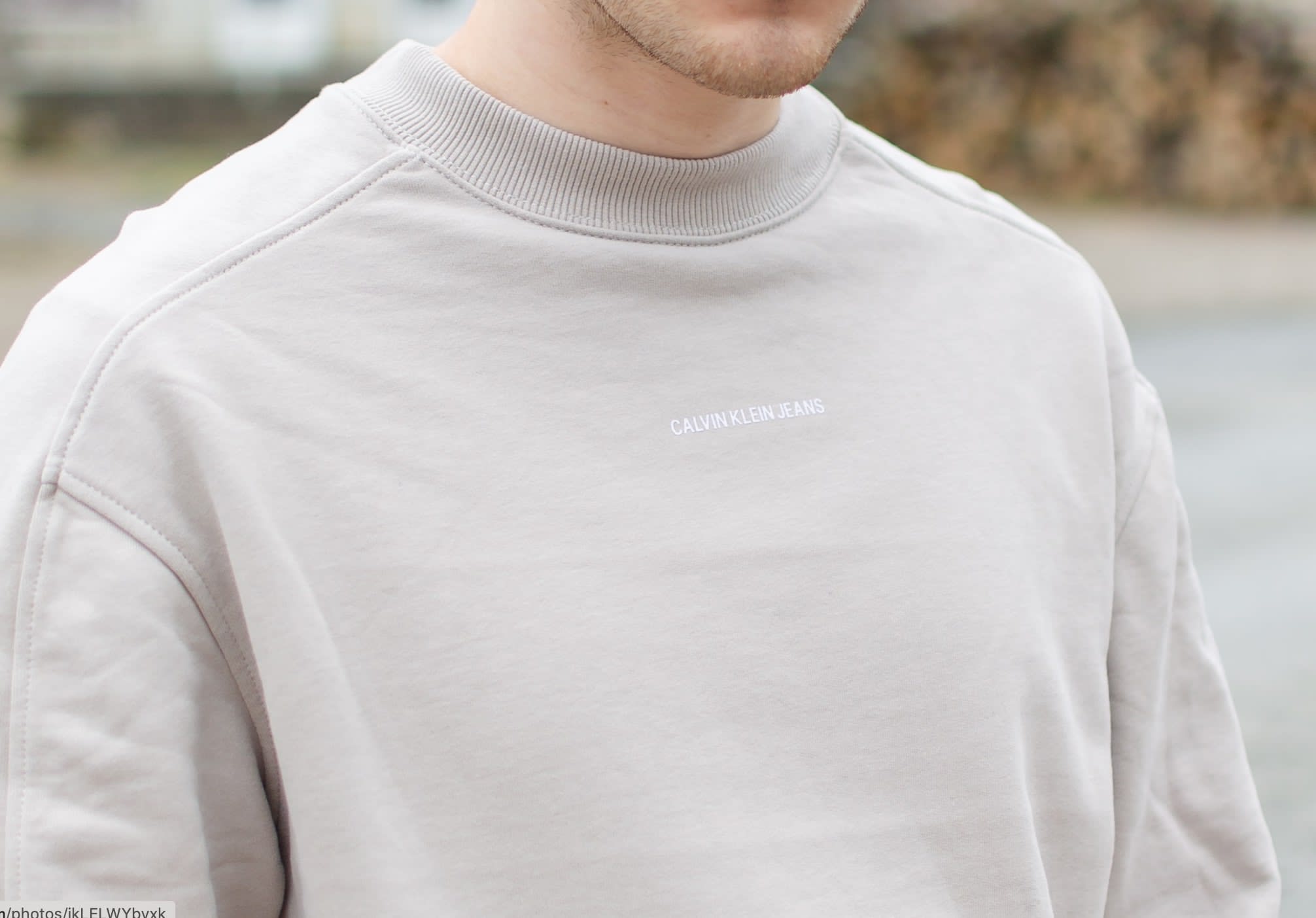 Man wearing a beige Calvin Klein sweatshirt