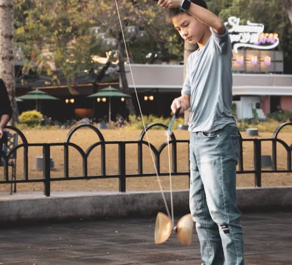 Boy playing with a diabolo in a park