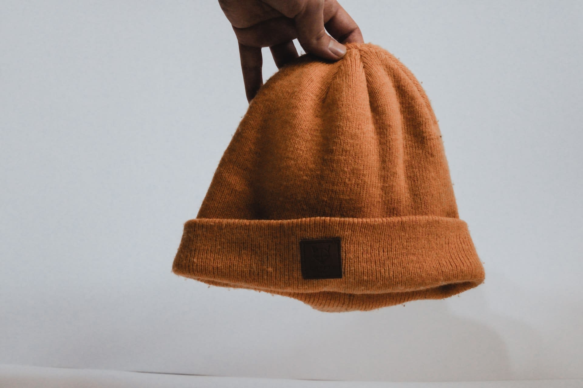 Person holding orange beanie