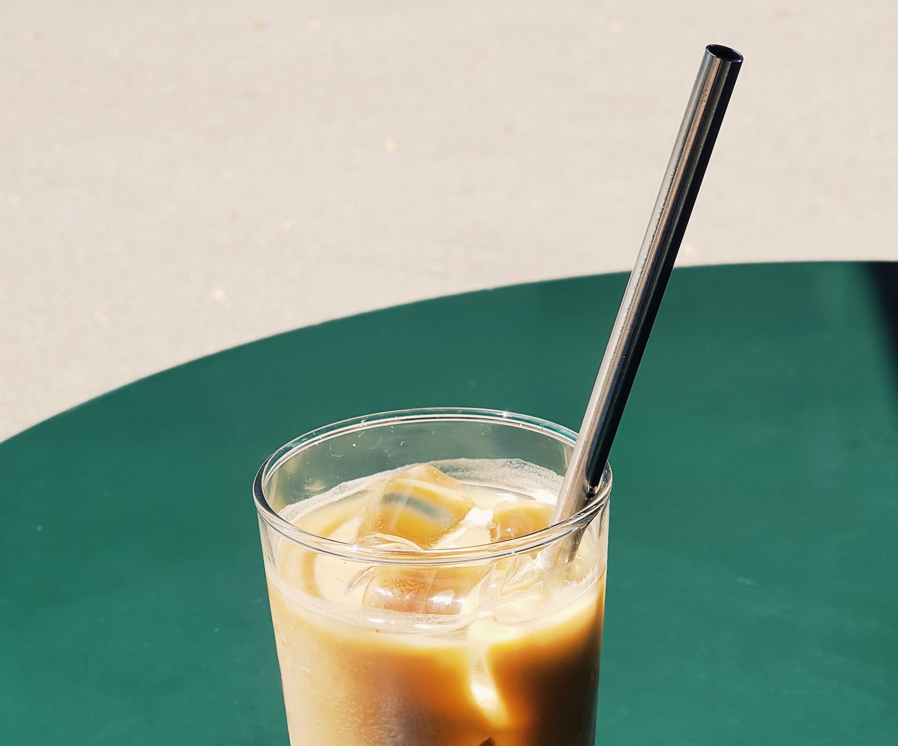 Close up of a coffee cup with a metal straw in it