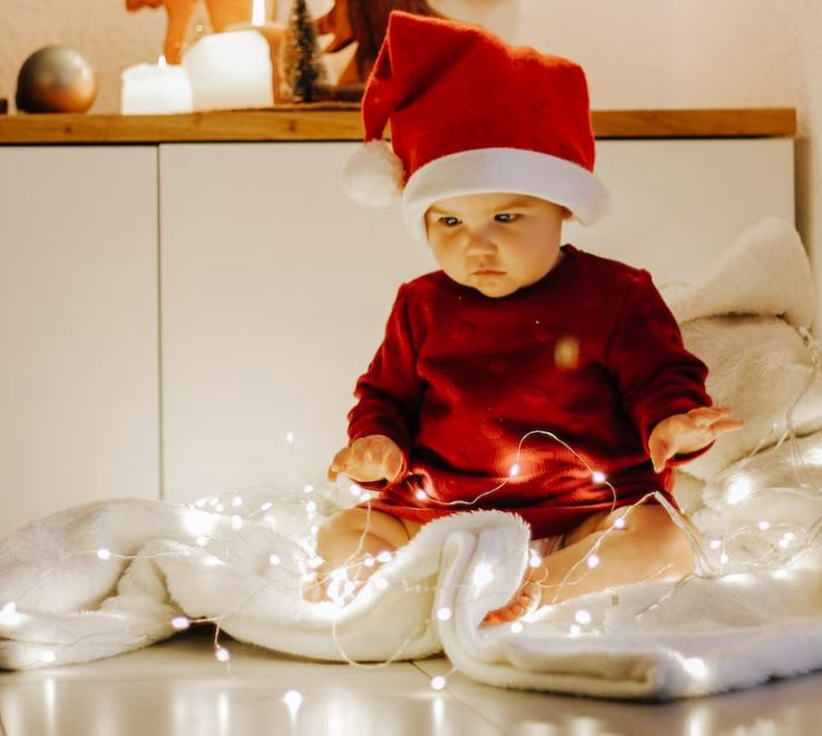 Baby sitting in fair lights dressed in Santa outfit