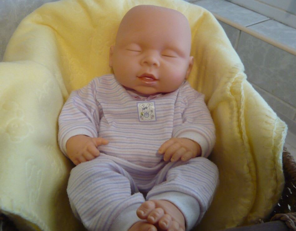 Baby doll sleeping in cot