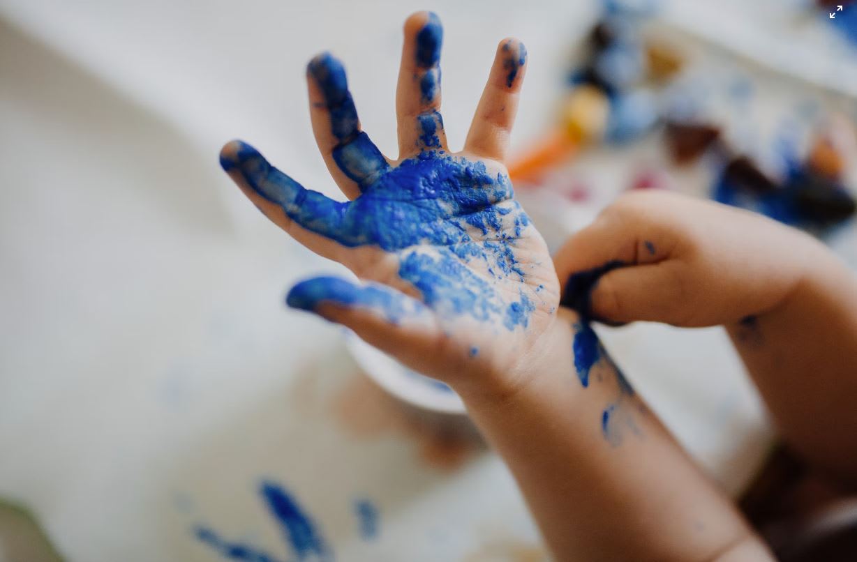 Childs hand with blue finger paint