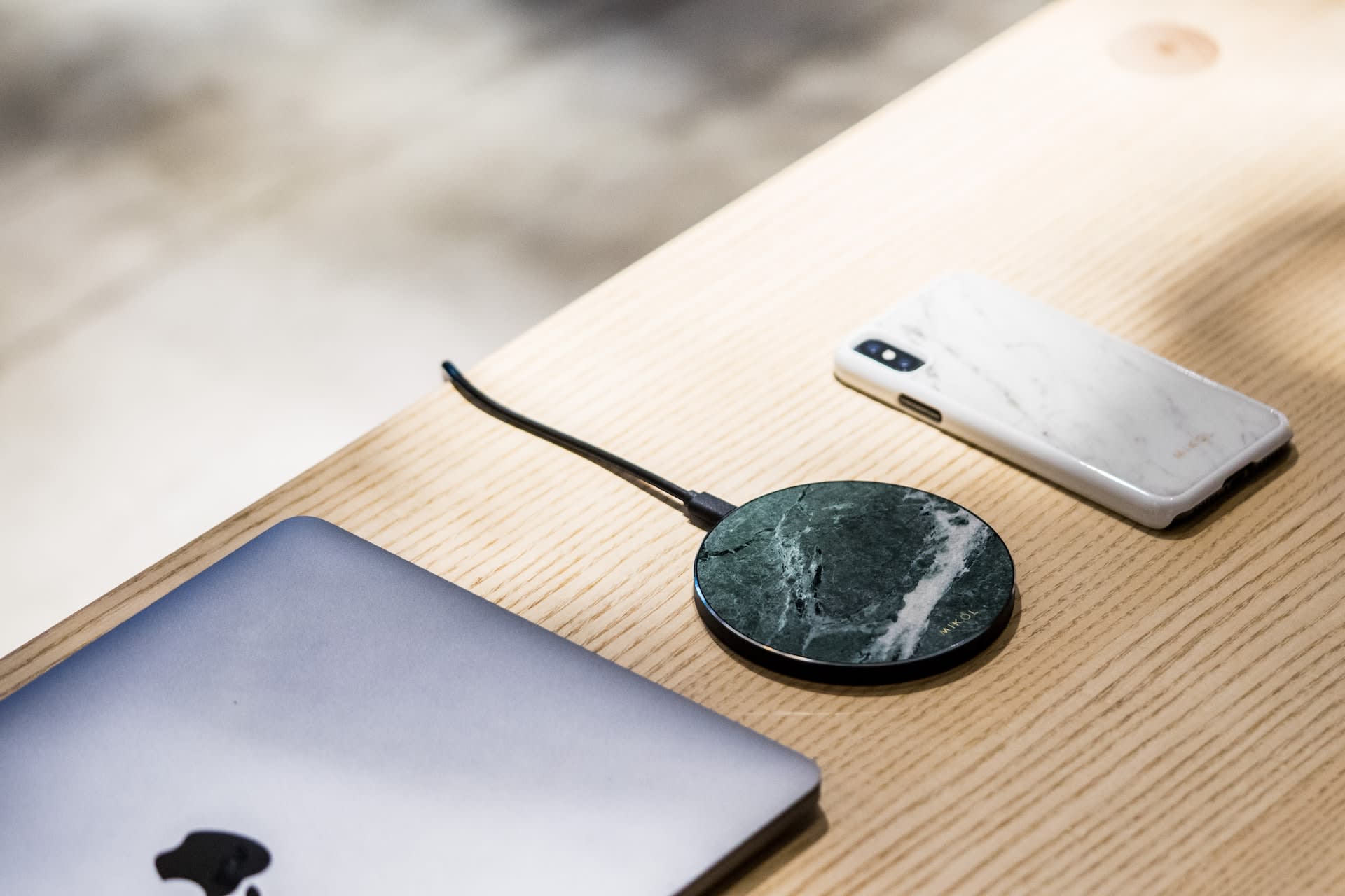 Marble print wireless charger beside laptop and phone