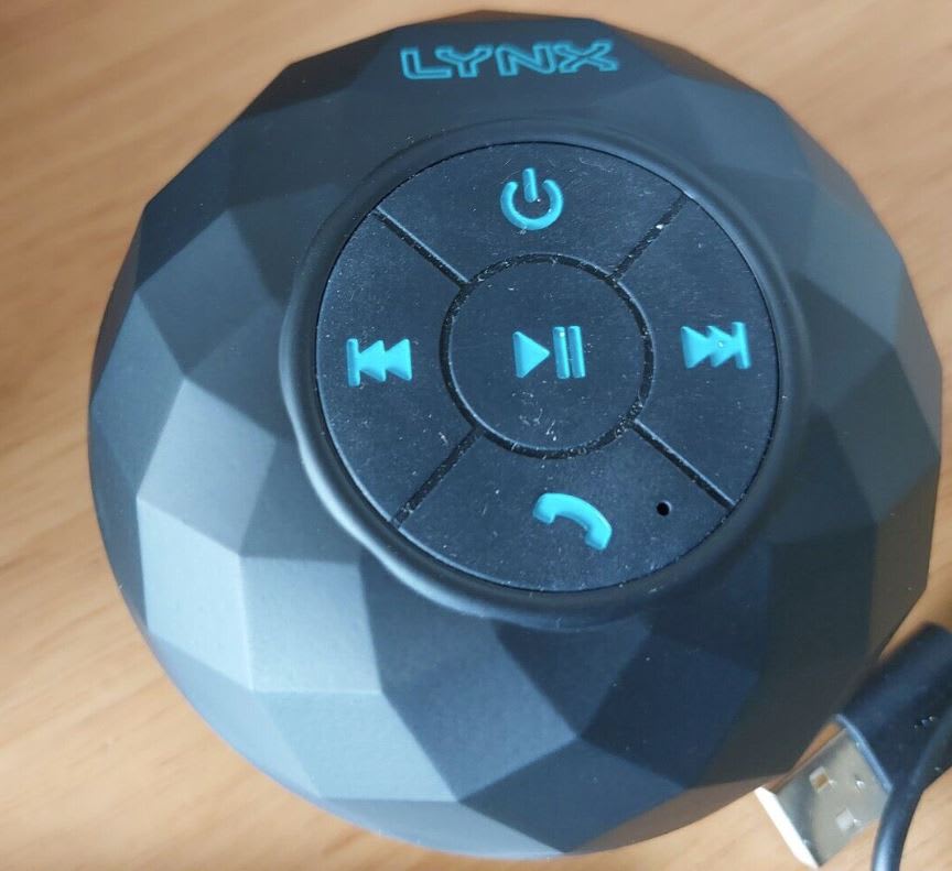 Second-hand blue shower speaker on wooden table