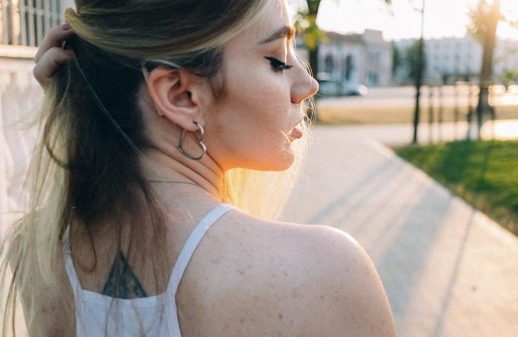 Woman walking down street with heart earrings