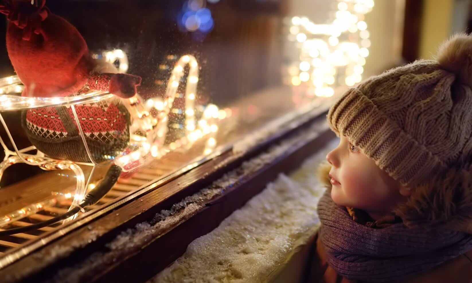 Boy looking into a Christmas window with wonder