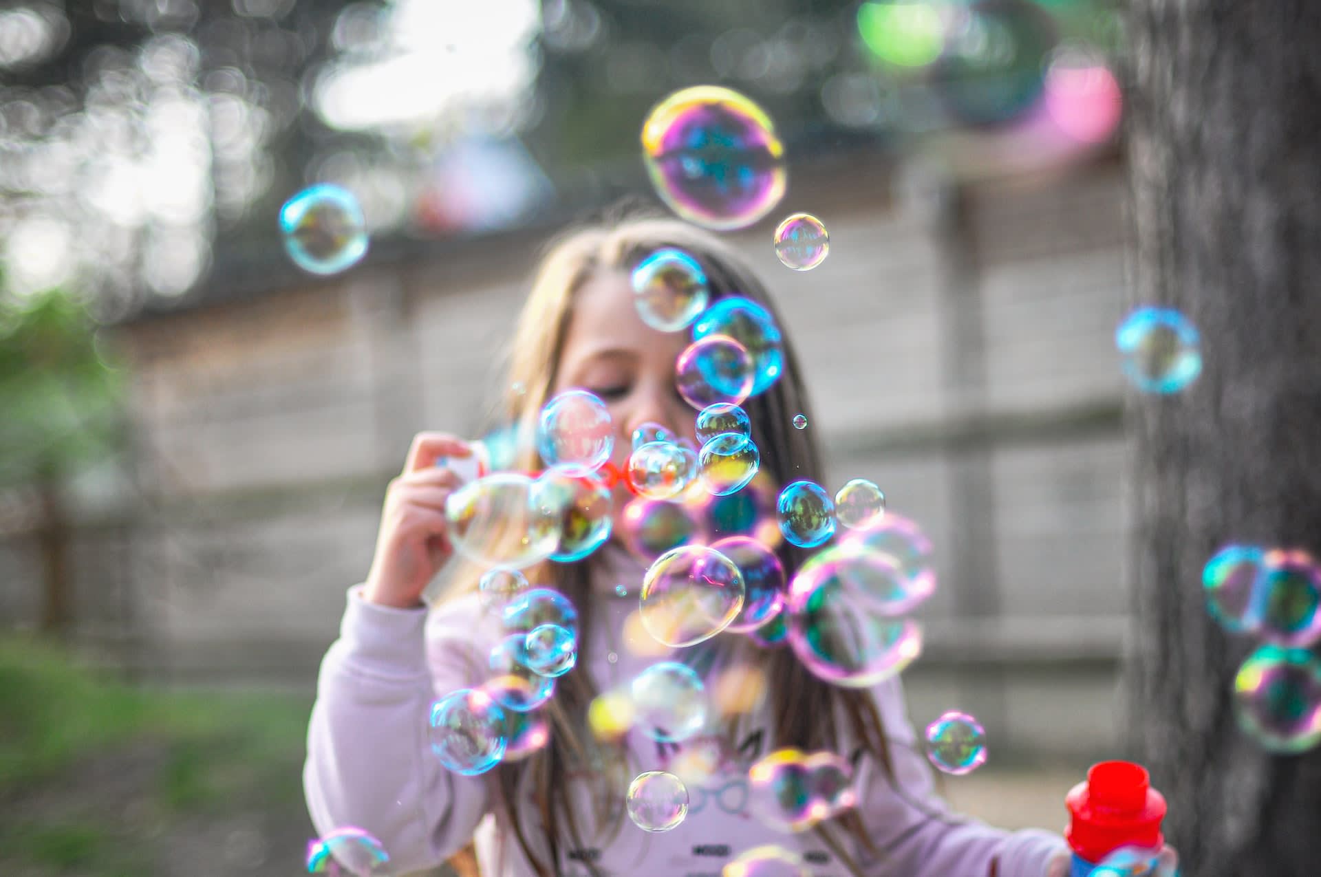 Little girl blowing bubbles with bubble wand