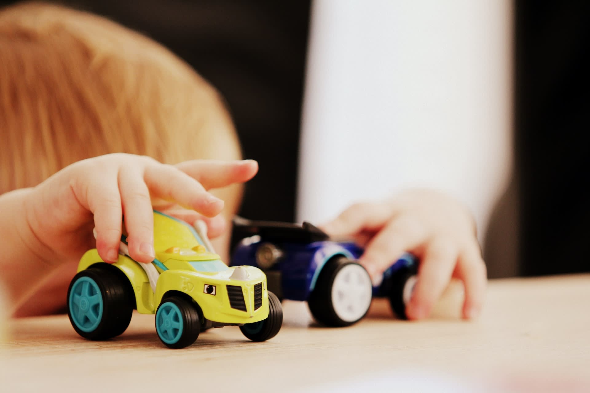 Kid playing with two pull back car toys