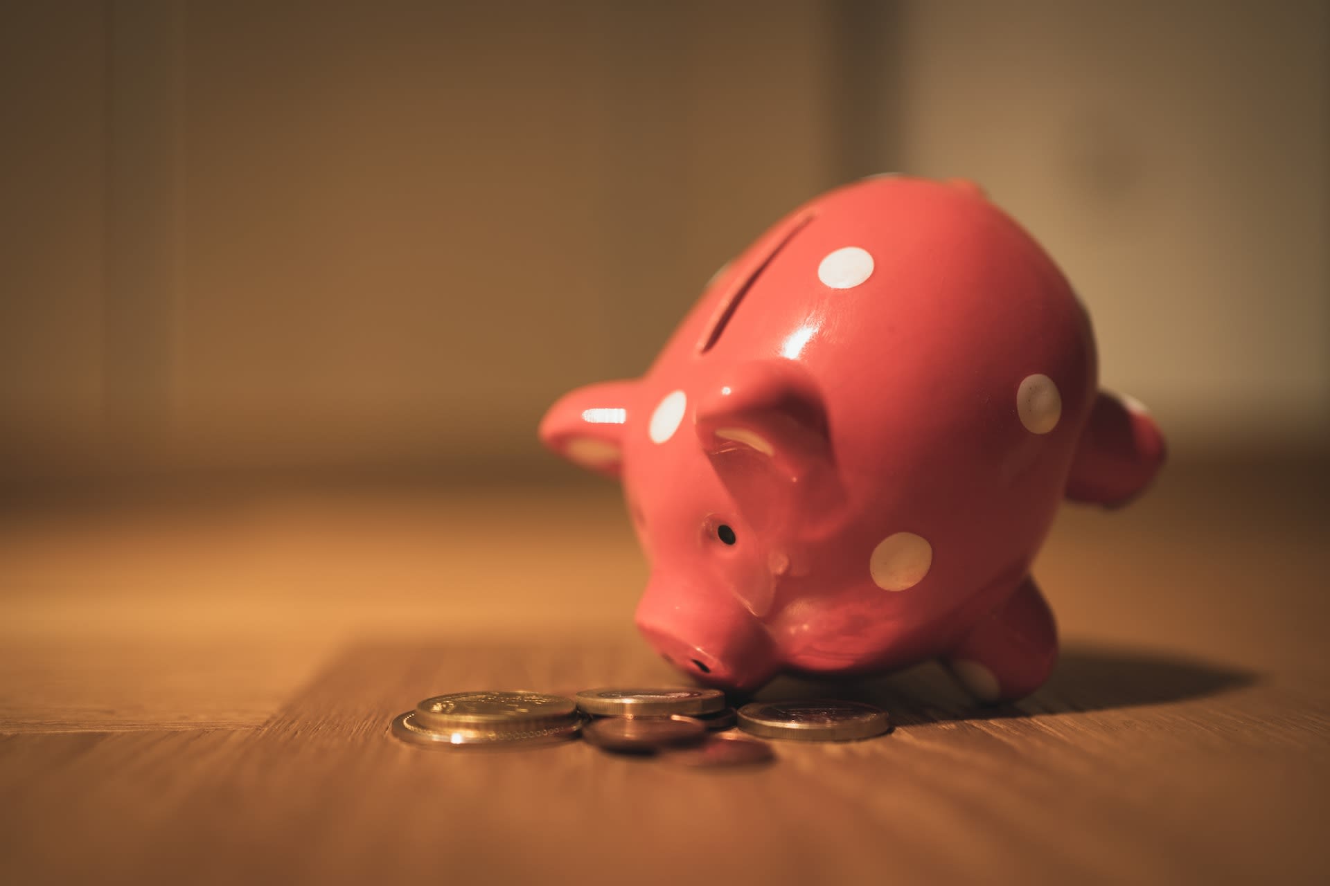 Pink second hand piggy bank with money next to it