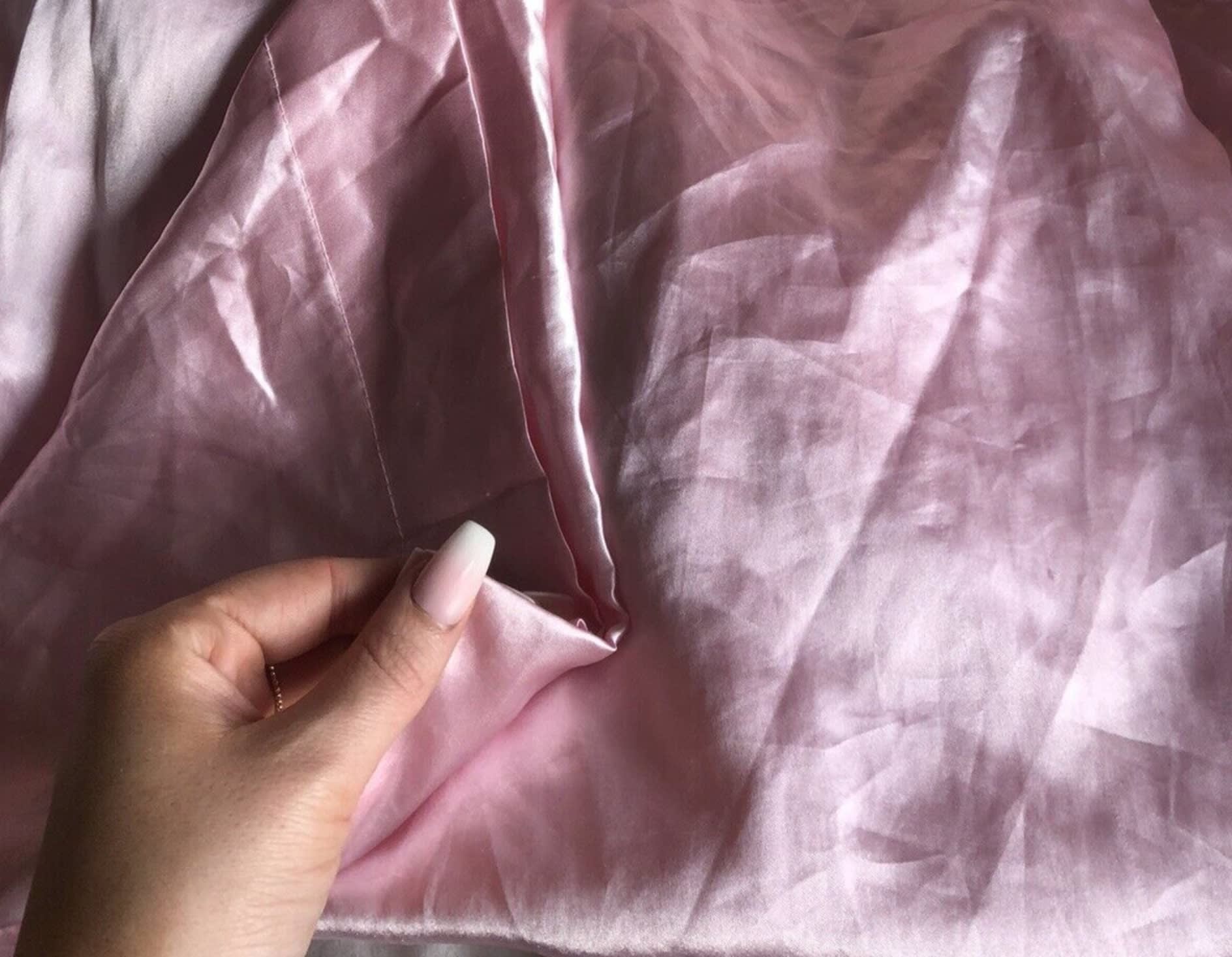 Woman feeling pink silk pillowcase