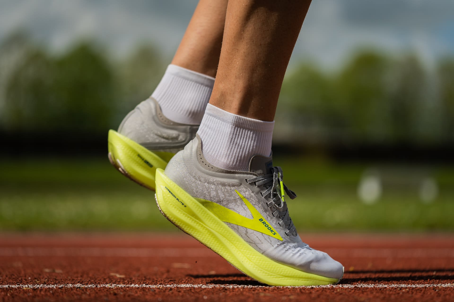 Man wearing white and yellow preloved running shoes