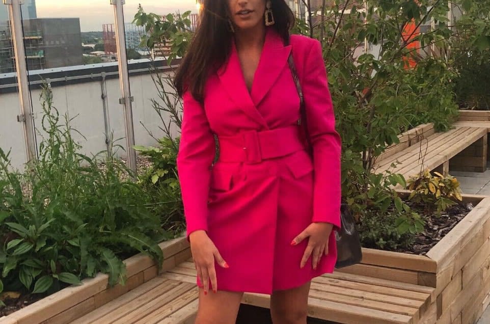 Woman wearing a pre-loved hot pink blazer dress