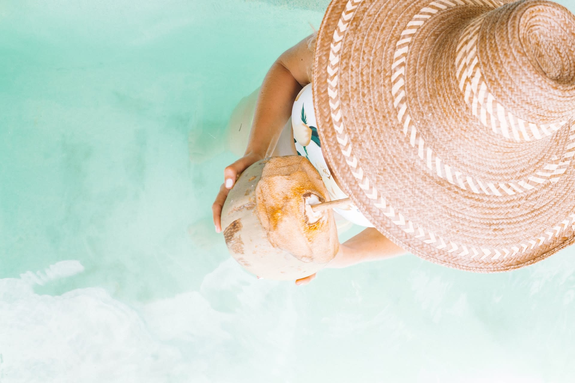 Woman wearing a second-hand straw sun hat at the pool