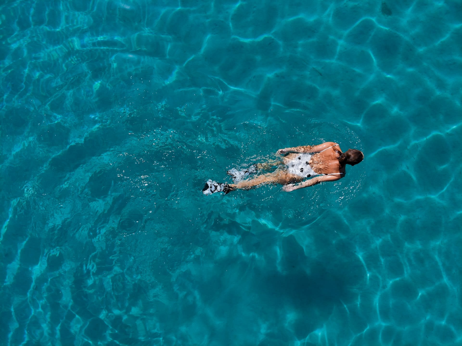 Woman swimming in a pre-loved polka-dot costume