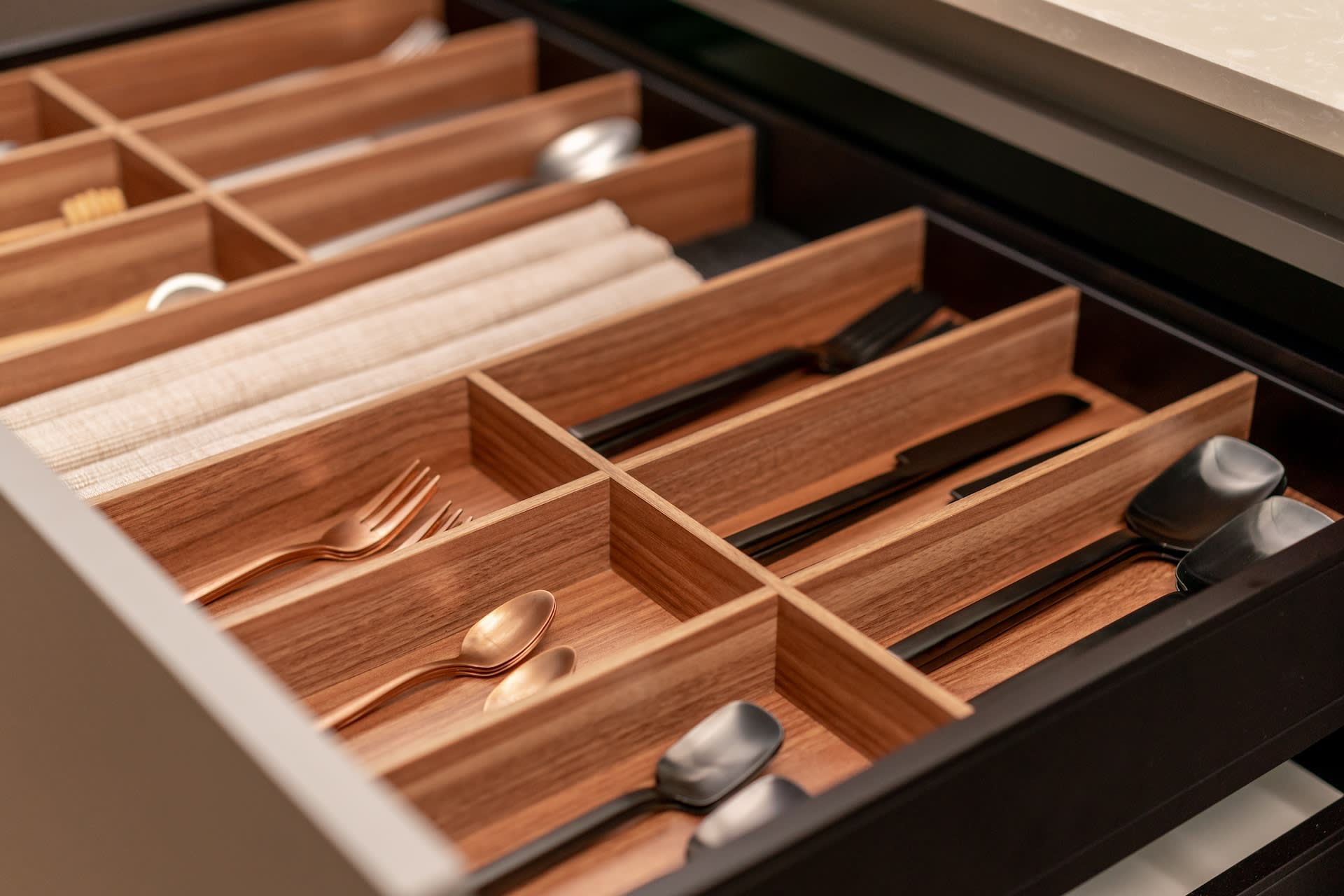 a cutlery set in a wooden drawer