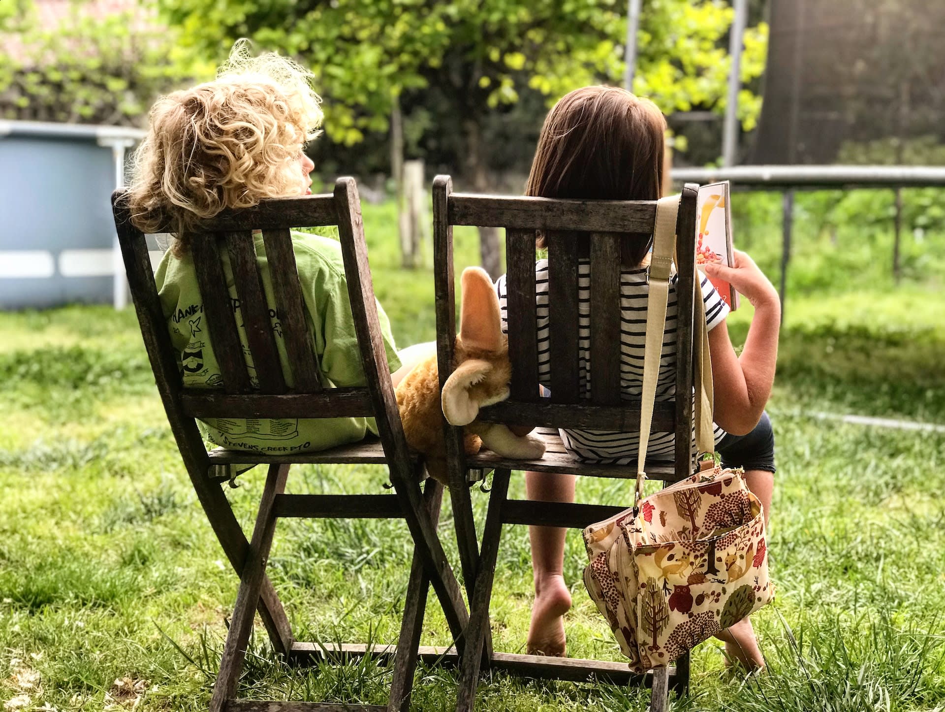 two girls sat on garden chairs