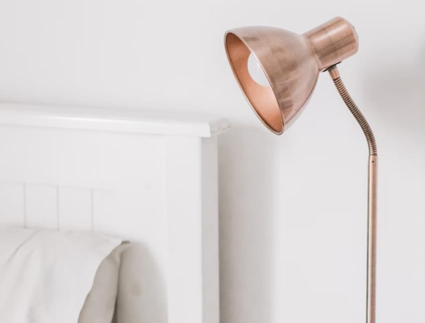 Pre-loved rose gold lamp on bedside table