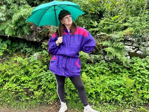 Ali styling a vintage rain jacket with Adidas leggings, converse and a green umbrella for a rainy walk.