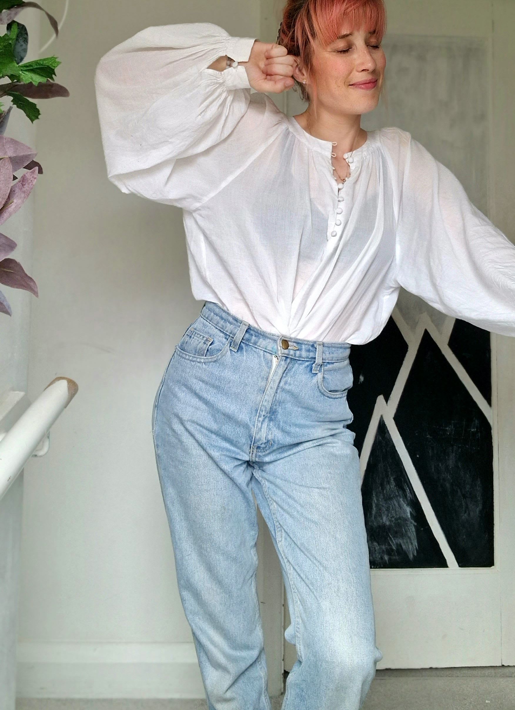 Pegz Preloved styling a white baloon sleeved blouse with blue light wash mom jeans.
