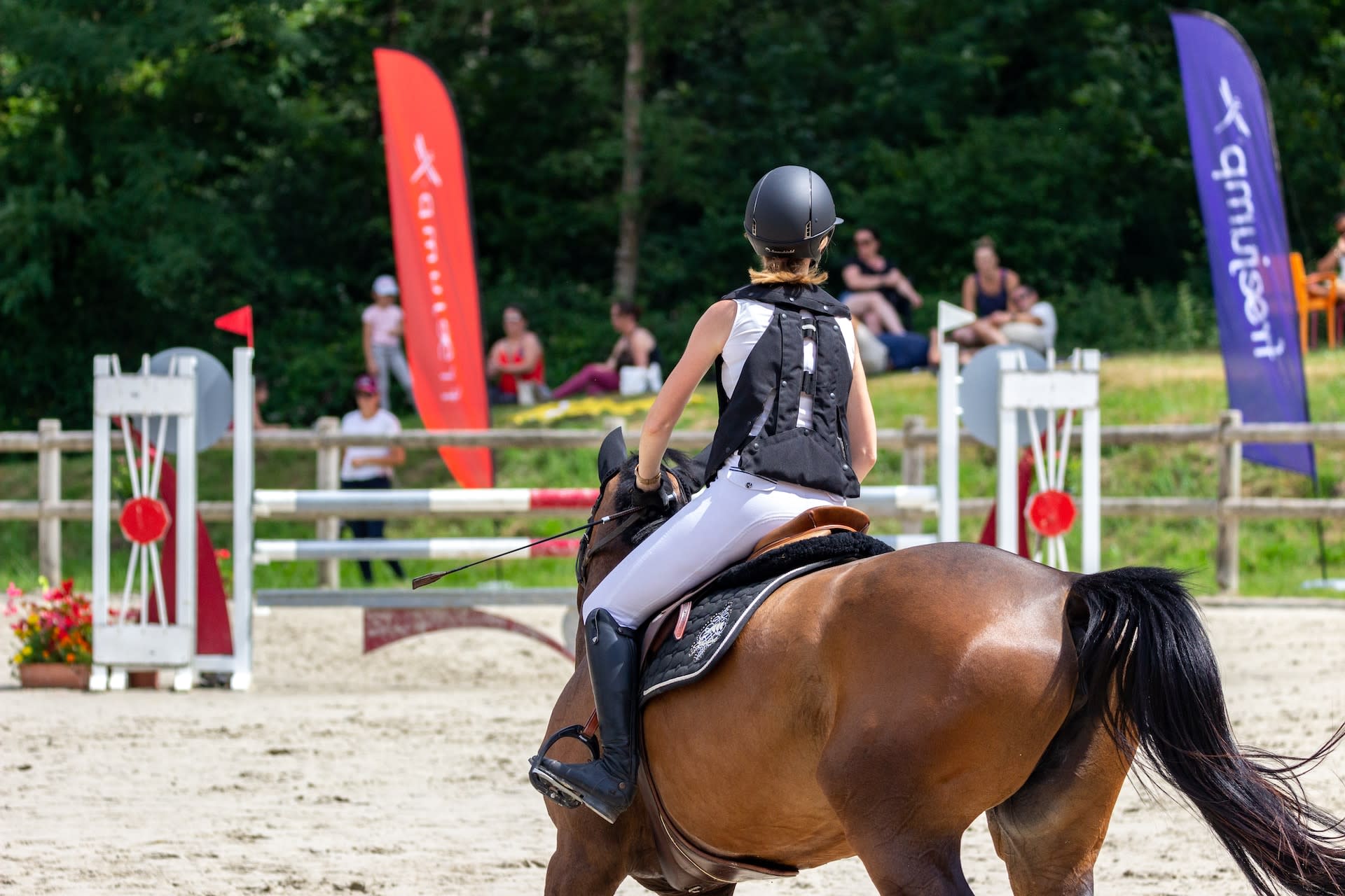 Woman showing a horse, wearing a body protector