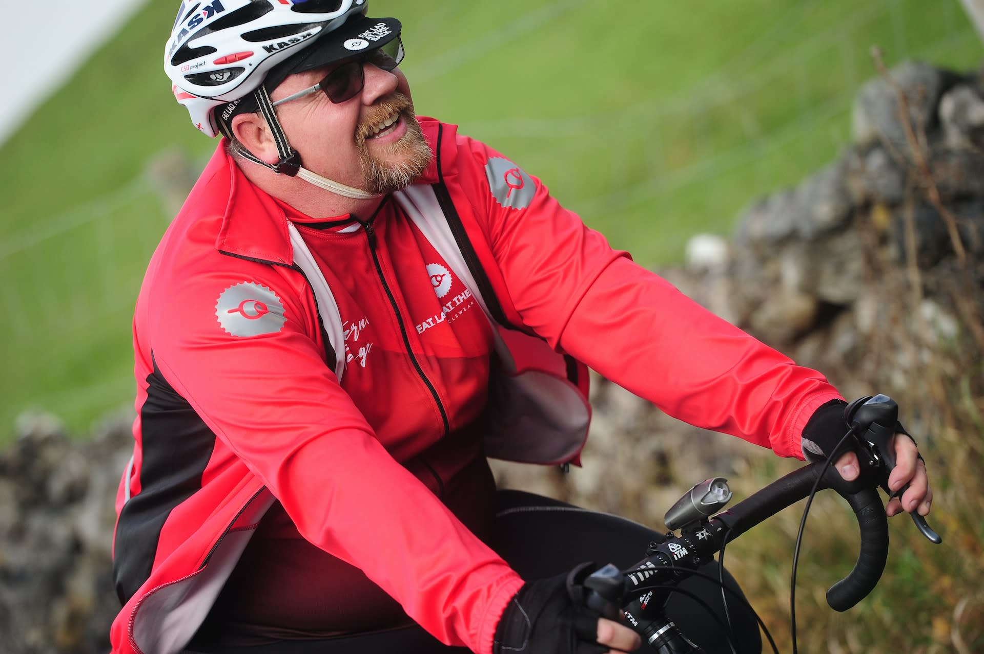 Man wearing a second hand red cycling jacket on a bike ride.