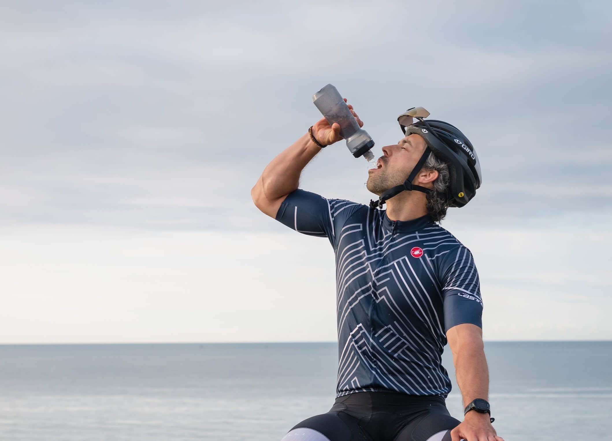 Cyclist drinking from a second hand water bottle.