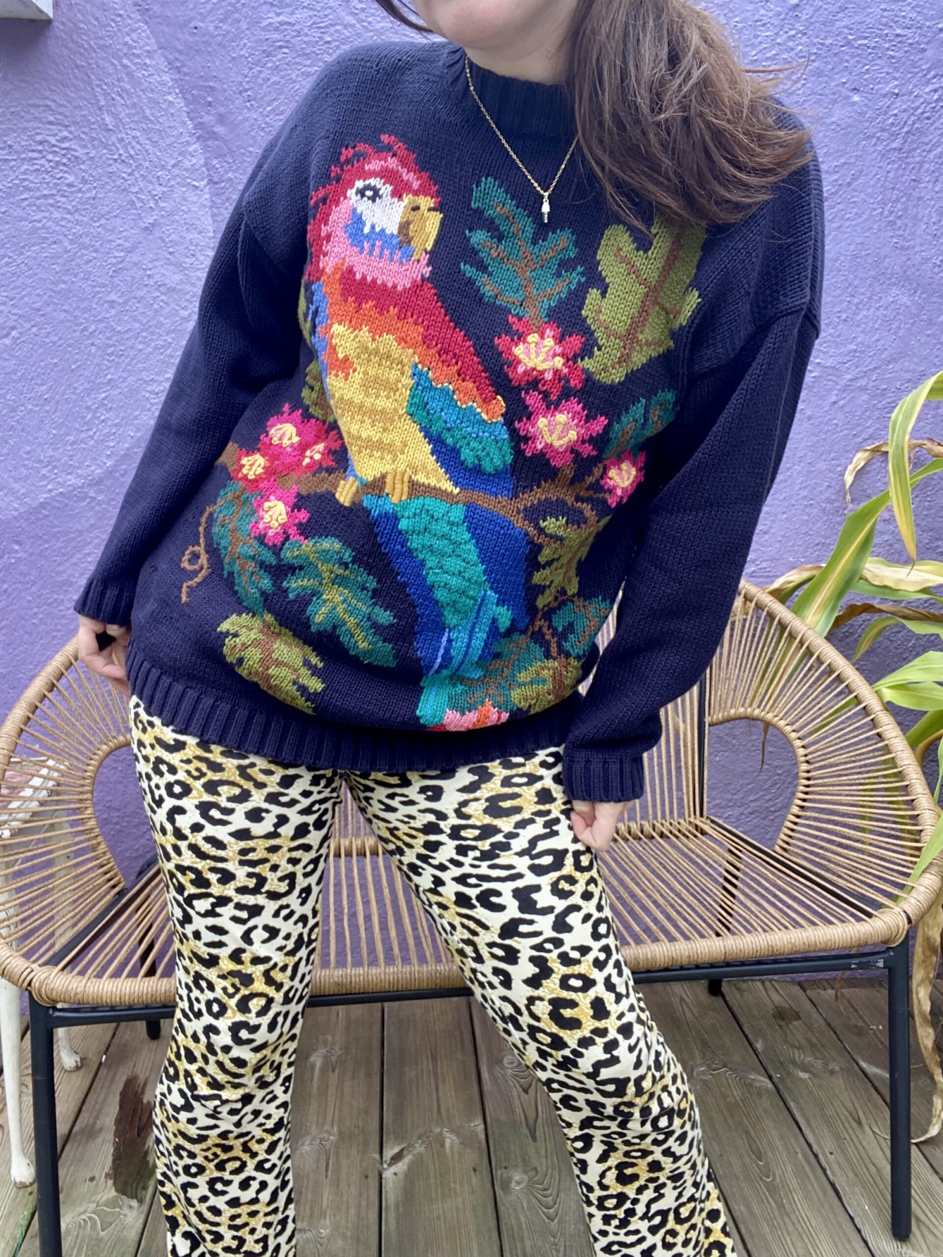 influencer little splash wears a colourful jumper and animal print pants in front of a purple wall