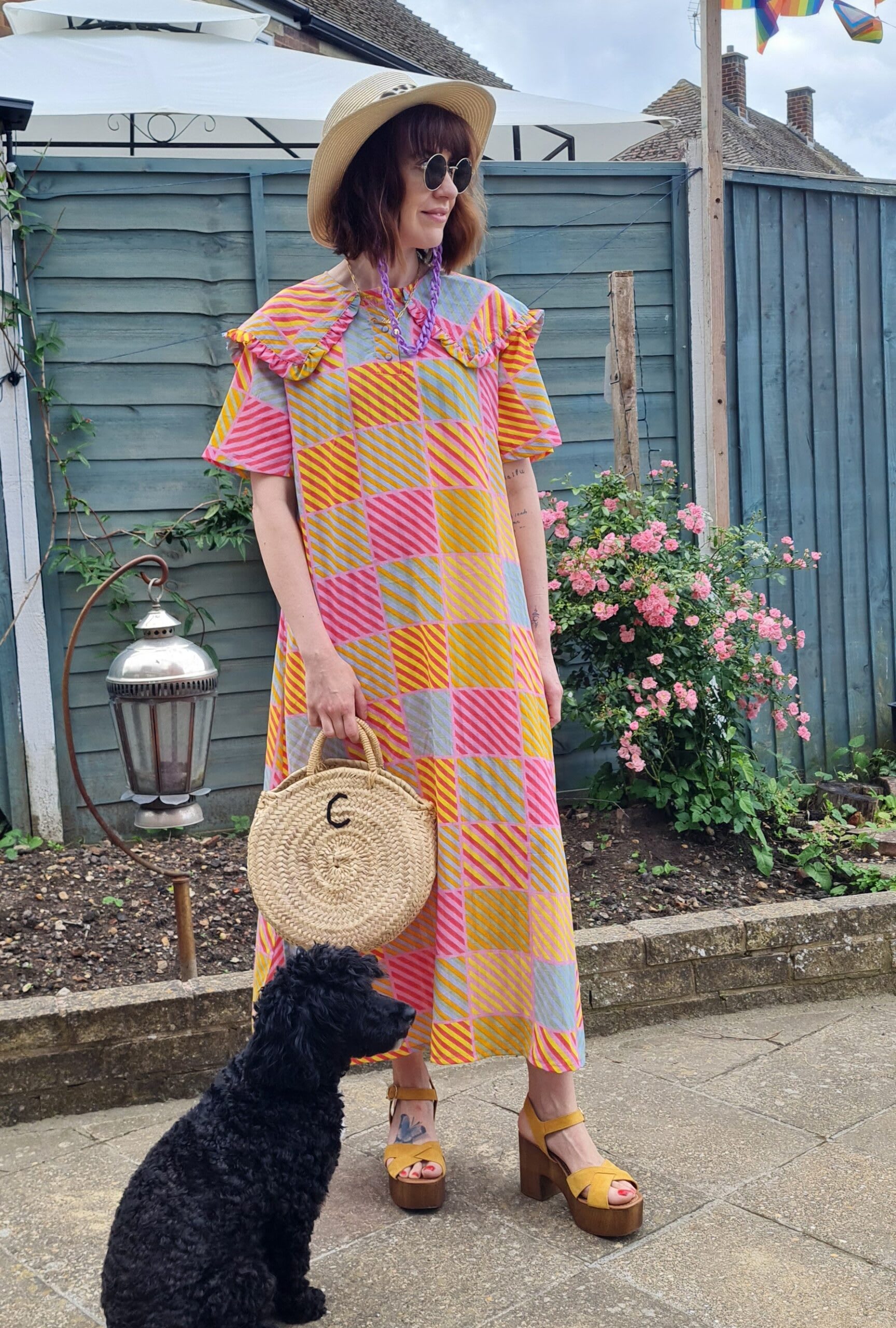 Carola standing in a garden wearing a patchwork maxi dress