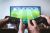 Loading placeholder for Two men playing a football console game