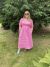 Loading placeholder for The thrifty edit wearing a pink dress and sunglasses standing in a park