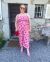 Loading placeholder for The thrifty edit standing wearing a pink jumpsuit with fruit on it with matching red glasses and bag