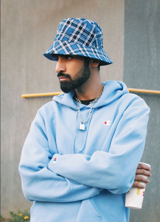 Man wearing a blue check bucket hat and matching blue hoodie