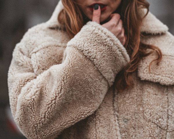 Close up of woman wearing a vintage beige fleece jacket