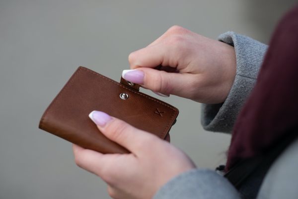 Woman opening a vintage brown leather purse
