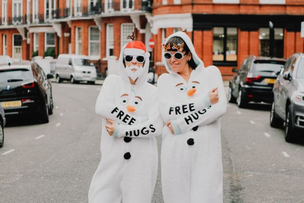Two people wearing preloved snowman onesies