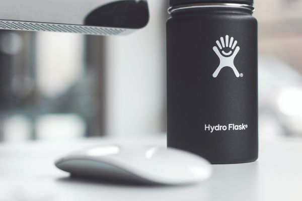 Black HydroFlask travel mug on a desk