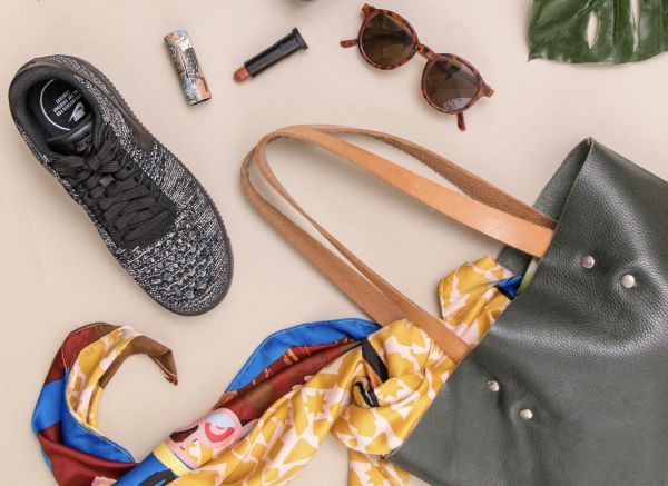 Stylish second-hand tote, trainers sunglasses and lipstick to show personal style