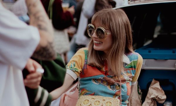 Woman smiling in a vintage 70s outfit to show benefits of buying second hand