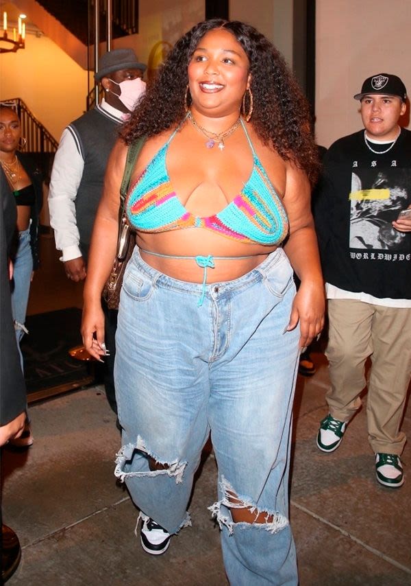 Lizzo wearing a crop top and jeans