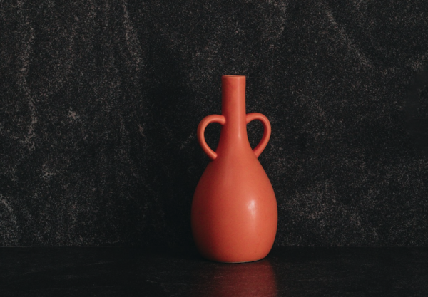 Vintage unique red vase against dark background
