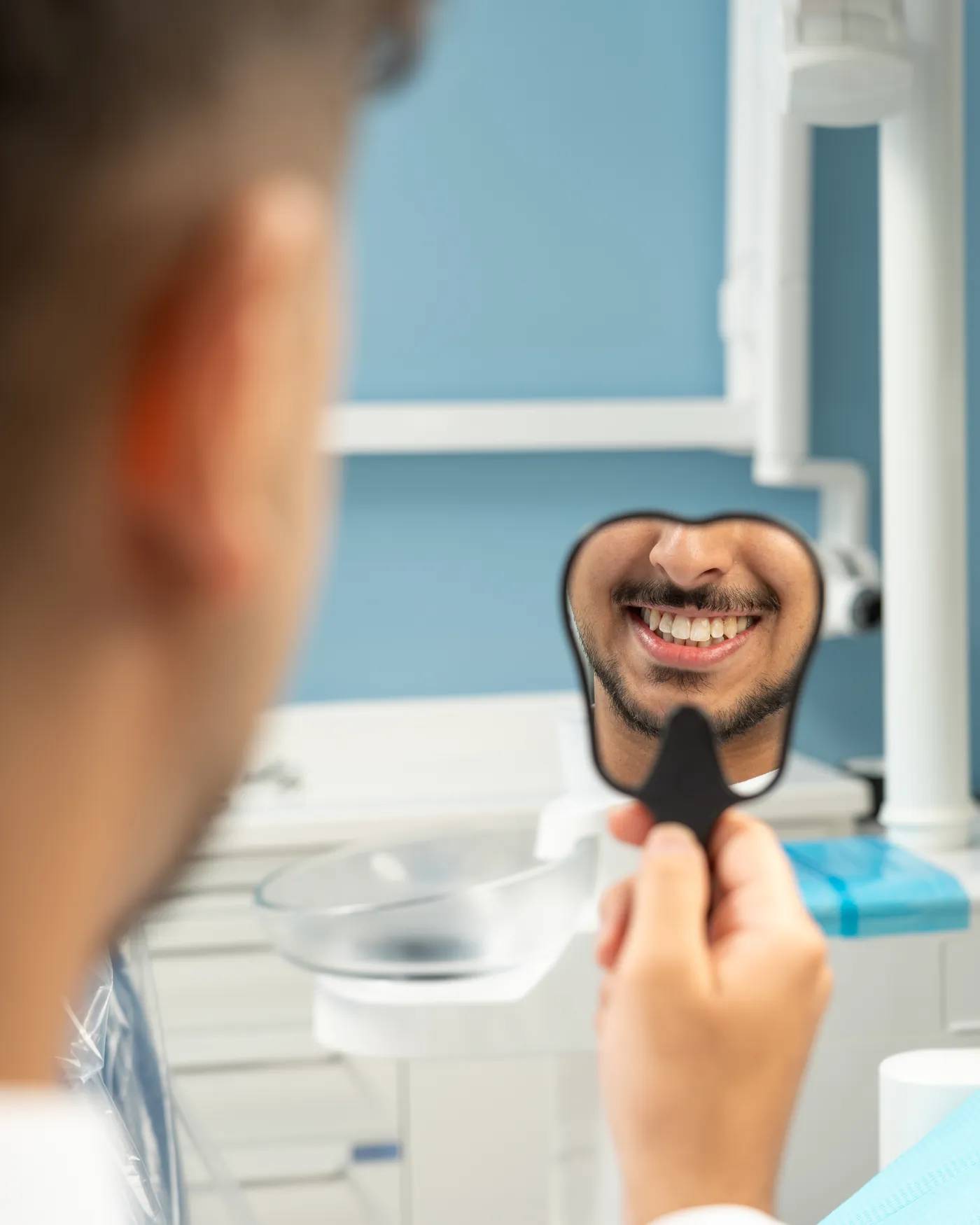 مريض في عيادتي ينظر إلى ابتسامته الجديدة في المرآة