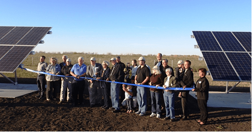 A group of people gathered at a solar farm ribbon cutting ceremony
